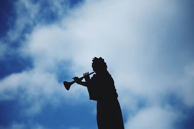 Low angle view of silhouette statue against sky