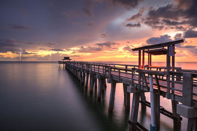 Pier over sea against sky during sunset