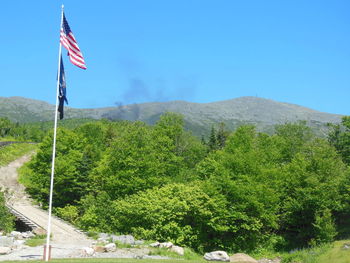 Scenic view of flag on mountain against sky