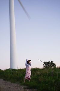 Woman standing on field against clear sky