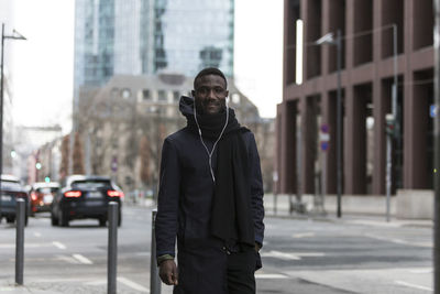 Man standing on street against buildings in city