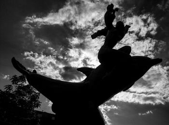 Low angle view of statue against cloudy sky