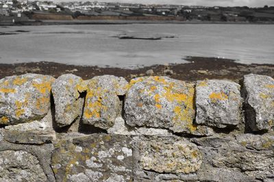 Close-up of old stone wall by river