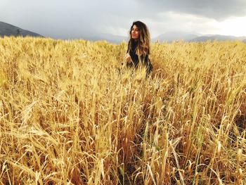 Full length of young woman standing in farm