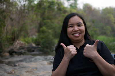 Portrait of smiling woman gesturing thumbs up