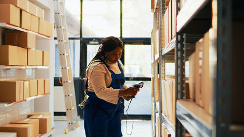 Portrait of young woman standing against building