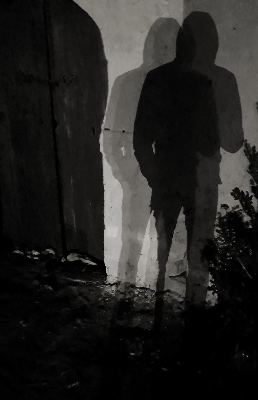 REAR VIEW OF SILHOUETTE MAN STANDING AGAINST BLURRED BACKGROUND