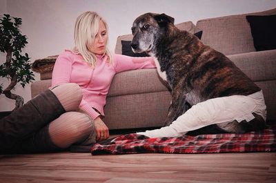 Woman with dog sitting at home