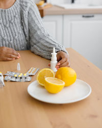 Midsection of woman having food on table