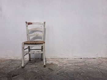 Empty chair against wall