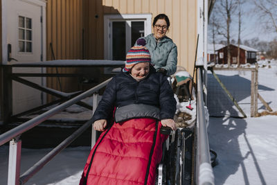 Mother having winter walk with daughter in wheelchair