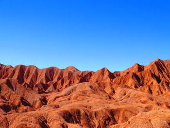 Scenic view of mountains against clear blue sky