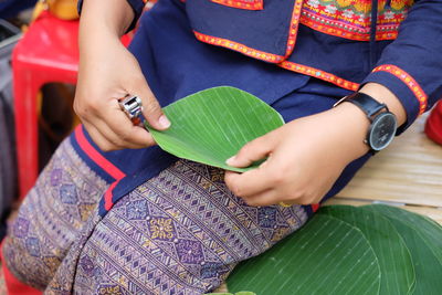 Midsection of woman holding leaf