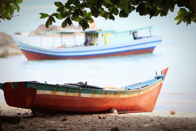 Boat moored on beach against sky