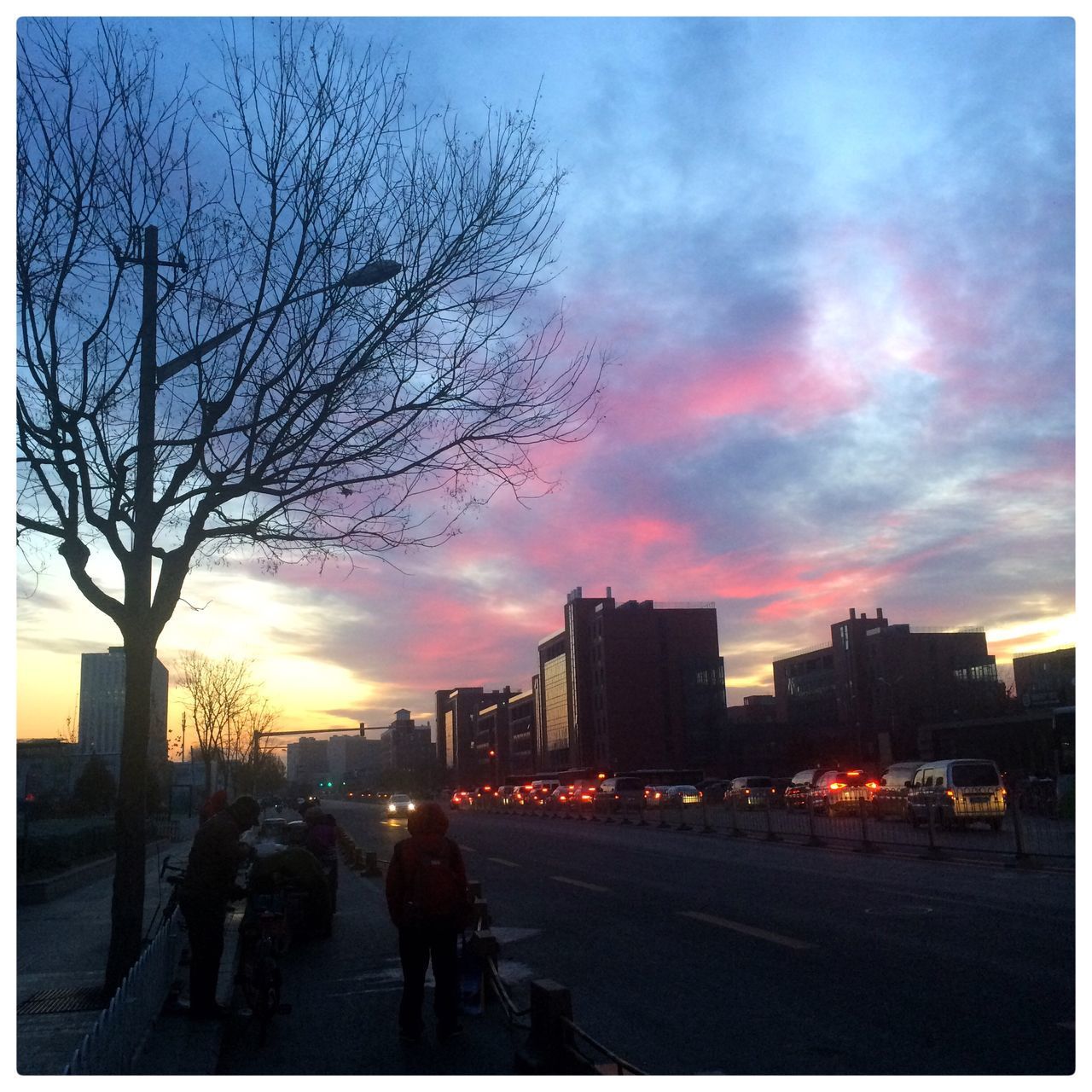 SILHOUETTE OF PEOPLE WALKING ON ROAD AT SUNSET