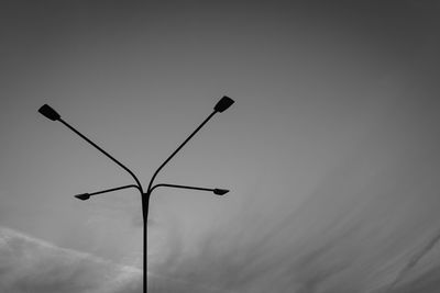 Low angle view of silhouette street light against sky