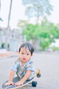 Portrait of cute boy sitting outdoors