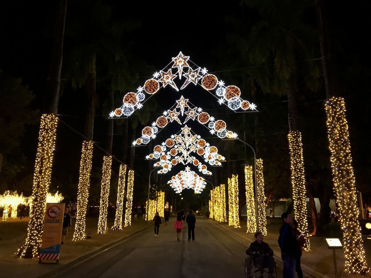 PEOPLE WALKING ON ILLUMINATED BUILDING