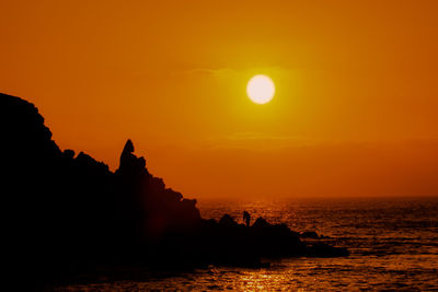 Scenic view of sea against orange sky