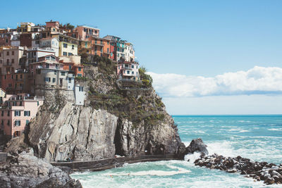 Scenic view of sea by cliff against sky