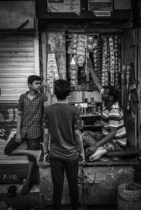 Rear view of people standing against built structure