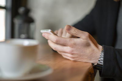 Cropped image of hand holding coffee cup