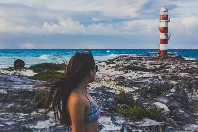 Low angle view of lighthouse on beach against sky