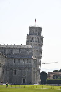 People in front of historical building against clear sky