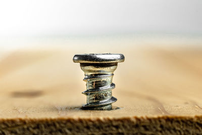 Close-up of rusty nail on table