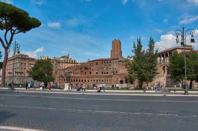 Group of people on road by buildings in city