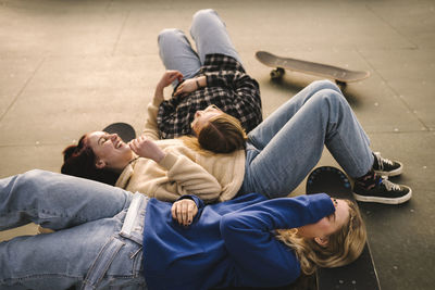 Teenage girls with skateboards relaxing in skatepark