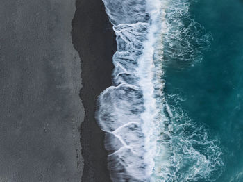 High angle view of waves rushing towards shore