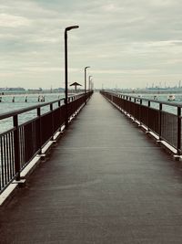 Footbridge over footpath against sky