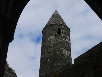 Low angle view of tower against cloudy sky