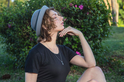 Young woman wearing hat against plants
