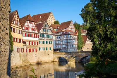 Buildings by river against sky
