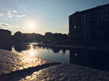 Reflection of buildings in city at sunset