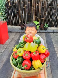 Portrait of boy with bell peppers basket