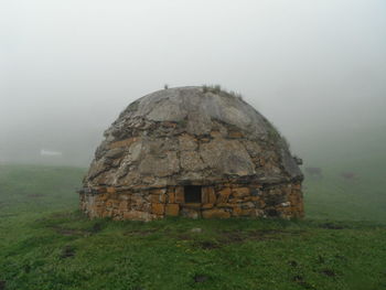 Built structure on field against sky