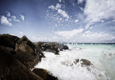 Waves splashing on sea against sky