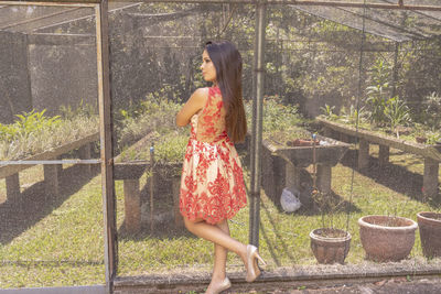 Side view of woman standing against plants