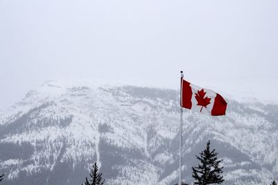 Low angle view of flag against sky during winter