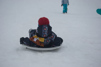 Boy tobogganing on snow