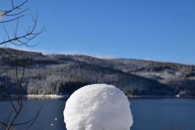 Close-up of frozen lake against clear blue sky