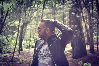 Handsome man standing in forest