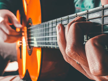 Cropped hand of man playing guitar