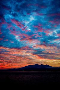 Silhouette of mountain against cloudy sky