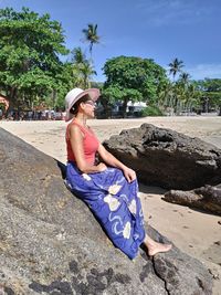 Woman sitting on rock at beach