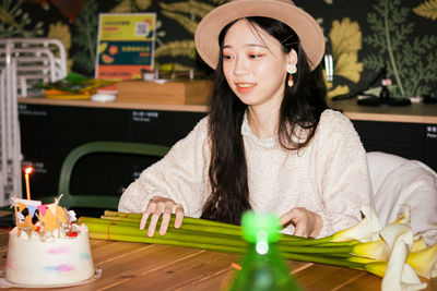 Portrait of young woman sitting on table