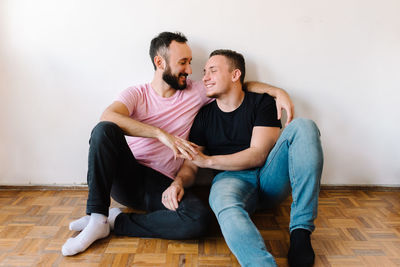 Gay couple laughing at home.